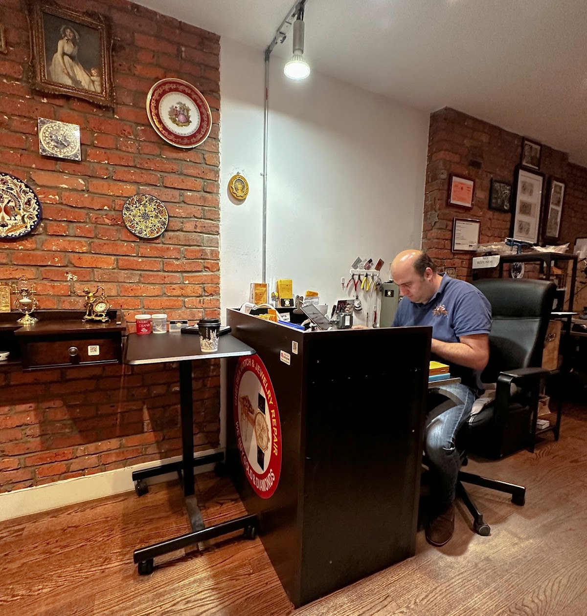 Boris at his workbench in Chelsea Watch and Jewelry Repair, brick walls behind